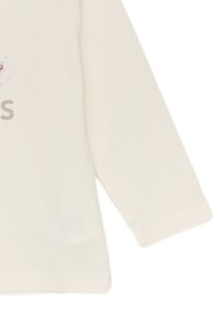 Maglietta a maniche lunghe di colore crema con testo argentato lucido e dettagli decorativi. Tessuto di cotone morbido con cuciture curate sulle maniche e l'orlo.