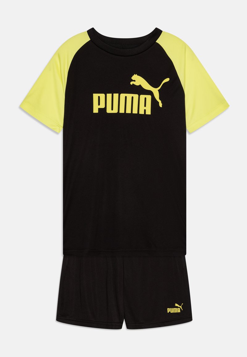 Svart sportoutfit bestående av en svart kortärmad topp med gula accenter och logotyp, tillsammans med matchande svarta shorts.