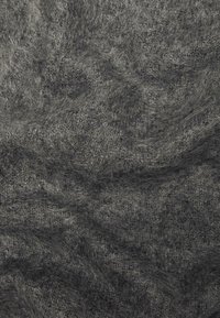 Tessuto in maglia grigio scuro, morbido e fuzzy, con fibre visibili e una superficie texturizzata e ondulata.