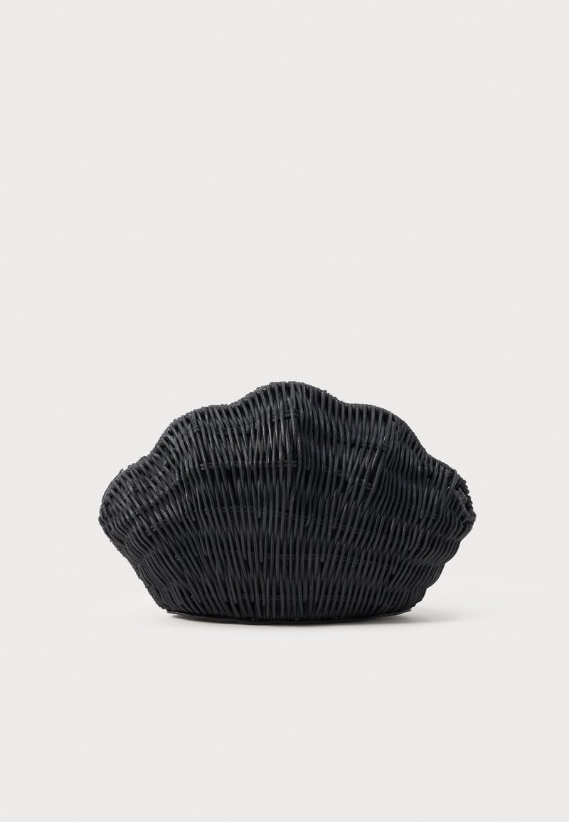 Μαύρη υφαντή τσάντα από ρατάν σε σχήμα κοχυλιού με δομημένη, στρογγυλεμένη σιλουέτα σε ουδέτερο φόντο.