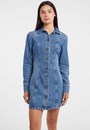 Robe en denim avec des manches longues, couleur bleu clair, fermeture à boutons sur le devant et coutures visibles. Dispose d'un col et d'une silhouette ajustée.