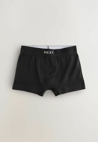 Shorts de boxe noirs en coton avec une taille élastique portant l'inscription "NEXT" en lettres blanches. Le design inclut une poche frontale et des coutures surpiquées.