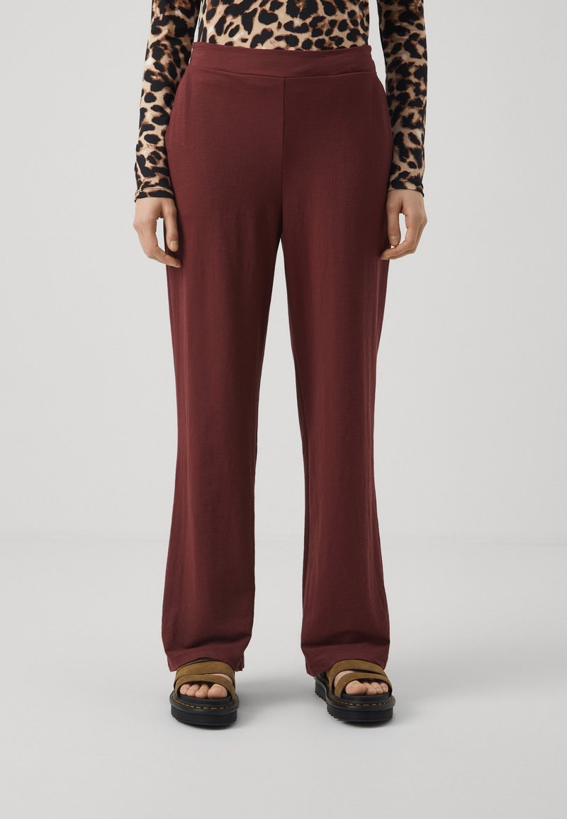 Vida-byxor i en vinröd färg, tillverkade av ett mjukt tyg med en subtil textur, med en hög, elastisk midja.