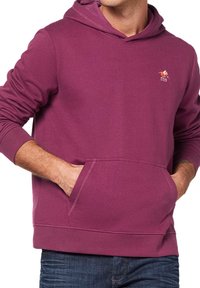 Bordowy hoodie z miękkiego połączenia bawełny, z przednią kieszenią, ściągaczami przy mankietach oraz małym haftowanym logo na klatce piersiowej. Casualowy krój.