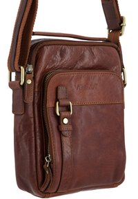 Brązowa skórzana torba na ramię z regulowanym paskiem, przednia kieszeń na zamek, mosiężne klamry oraz wytłoczone logo "VENEZIA" na przednim panelu.