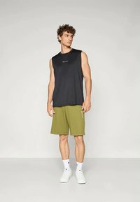 Melna bezpiedurkņu krekliņš un olīvu zaļas šortus, kokvilnas audums, brīvs griezums, ar logo akcentiem, kombinēts ar baltām zeķēm un apaviem.