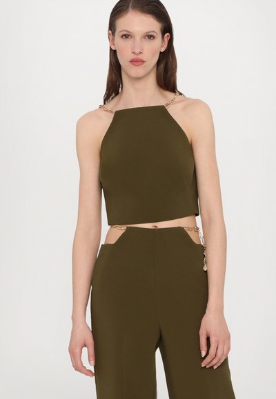 Haut court vert olive avec un décolleté carré et des accents de bretelles en chaîne, fabriqué à partir d'un tissu lisse, avec une découpe à la taille.