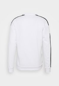 Sudadera blanca de manga larga, con puños de canalé y cuello redondo. Presenta rayas negras a los lados y una textura suave de mezcla de algodón.