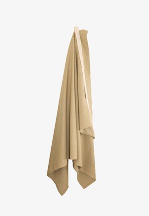 Tkanina bež boje, prepletena i prebačena s gornje strane glatkim, jednobojnim naglaskom; ima teksturirani uzorak i mekan, tekući oblik.