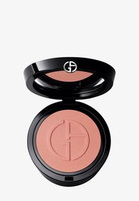 Rund blush-kompakt med en glanset svart ytre. Inni er det en myk ferskenfarget rouge med et subtilt preget logomønster. Glatt, matt tekstur.
