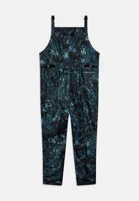 Svarta och teal-mönstrade hängselbyxor med justerbara axelremmar, elastisk midja och två dragkedjefickor på framsidan. Mjuk tygtextur.