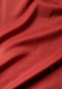 Textilstoff, mittelschwer, einfarbig in rötlich-brauner Farbe, glatte Textur mit leichtem Glanz, mit sanften Falten und Drapierungen.