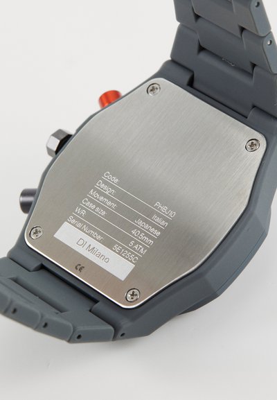 Gray watch with a rubber strap, stainless steel back featuring engraved details, including movement, case size, and water resistance.