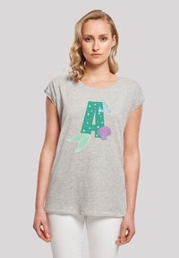Tricou gri cu mânecă scurtă, care prezintă o mare literă verde „A” cu modele de stele, bule și un grafic cu cochilie pe față.