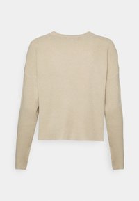 Beżowy sweter w prążki z długimi rękawami, skróconą długością, okrągłym dekoltem i teksturowanym materiałem. Posiada boczne szwy dla luźnego fasonu.