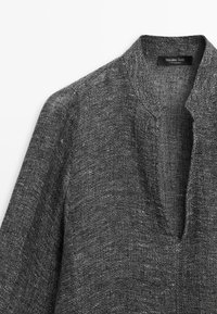 Mørkegråstrikket sweater med struktur, V-hals og stående krave, mærket Massimo Dutti, lavet i Marokko.