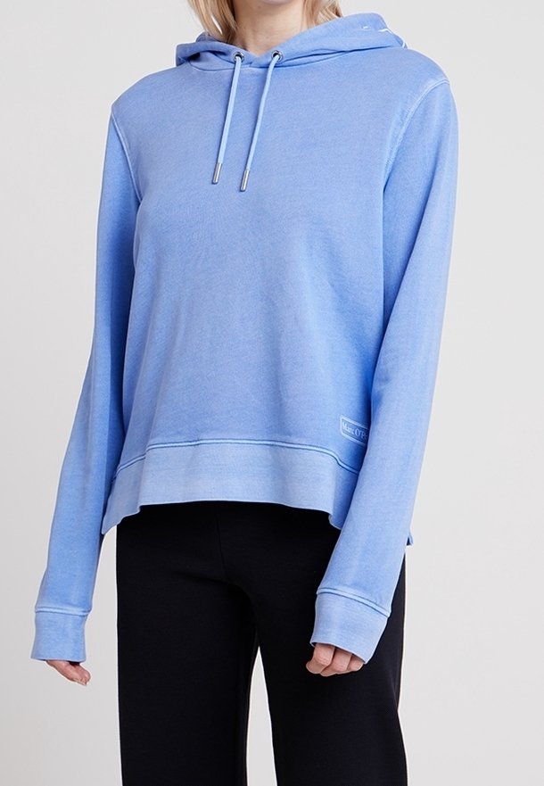Sudadera con capucha de color azul claro hecha de una tela suave, con mangas largas, un ajuste relajado y una etiqueta con logo en la parte delantera. Costuras limpias y cordones.