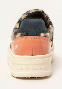 Zapatilla con parte superior de estampado de leopardo, panel de cuero azul marino, tapa de talón color coral y suela blanca texturizada con marca en relieve.