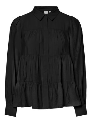 Blouse noire à manches longues avec un tissu plissé à niveaux, col pointu, boutons cachés sur le devant et poignets ajustés.