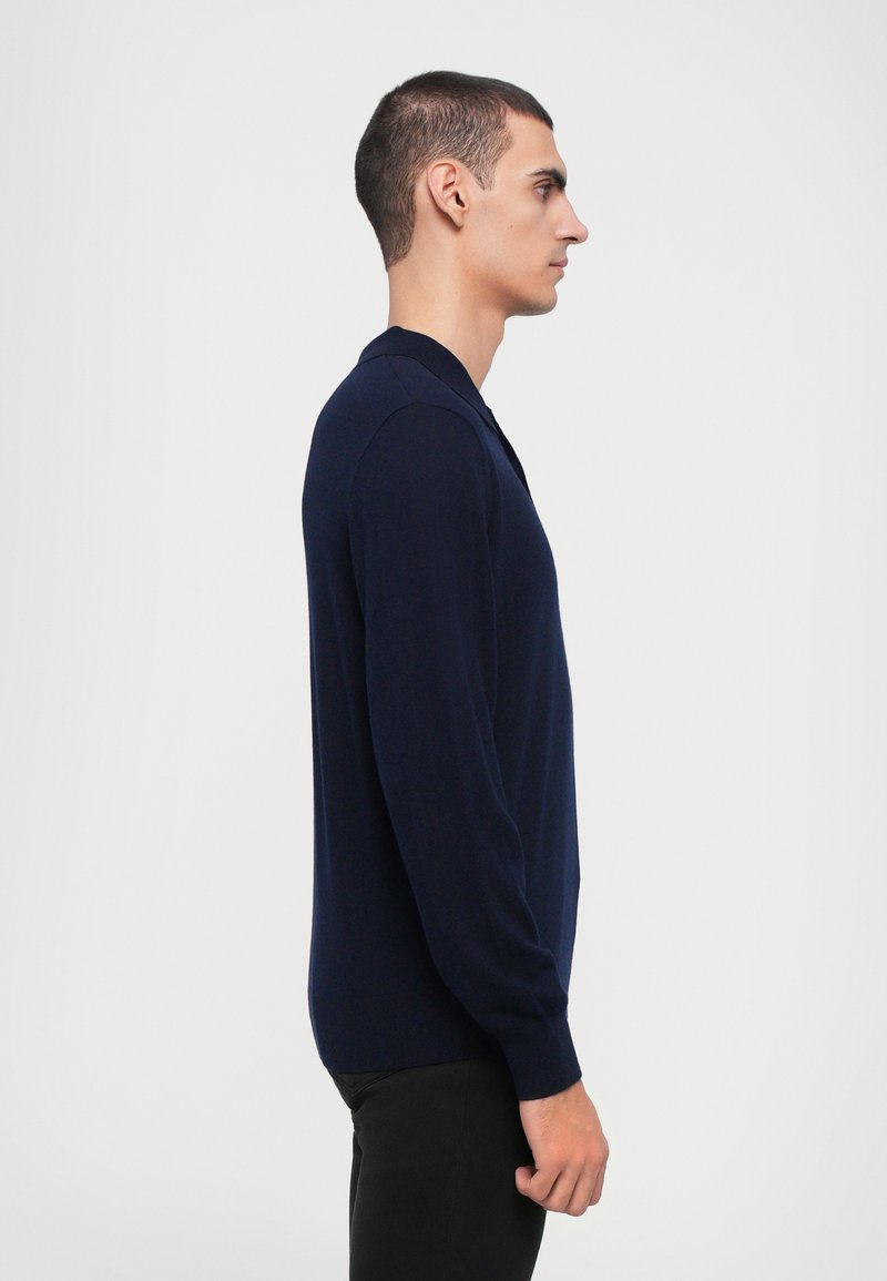 Marineblauwe lange mouwen pullover met een polokraag, gemaakt van glad materiaal, met een slim-fit ontwerp en geribde manchetten voor een op maat gemaakte uitstraling.