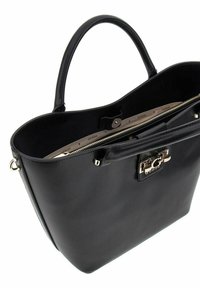 Bolso tote de cuero negro con cierre de cremallera, que presenta un broche plateado brillante y un bolsillo interior. Textura suave y forma estructurada.