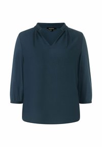 Blouse bleu marine en tissu lisse, avec un col en V, de légers plissés aux épaules et des manches trois-quarts.