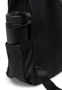 Zaino nero con una tasca laterale che contiene una bottiglia d'acqua nera. Realizzato in tessuto resistente con finitura testurizzata e tracolla regolabile.