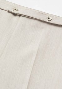 Beżowe spodnie o gładkiej fakturze, z zapięciem na guzik i plisami w pasie dla dodatkowego detalu. Prosty design zapewnia wszechstronność.