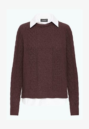 Kestenasti pleteni pulover s teksturiranim uzorkom, s bijelom košuljom ispod. Dugi rukavi i blago skraćeni kroj.