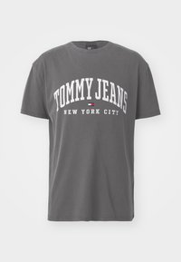 Gray cotton t-shirt with short sleeves, featuring white text "TOMMY JEANS NEW YORK CITY" in a bold, arching font.
