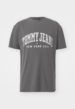 Šedé bavlněné tričko s krátkým rukávem, na kterém se nachází bílý text "TOMMY JEANS NEW YORK CITY" v tučném, zakřiveném písmu.