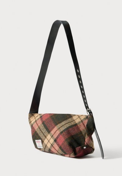 Pledēts plecu soma ar vilnas ārpusi zaļās, sarkanās un bēšās nokrāsās. Aprīkota ar melnu ādas siksnu un aizdares pogu detaļu.