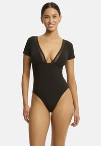 Costume da bagno intero nero con maniche corte, scollatura a V profonda, pannelli in rete e aperture elevate per le gambe. Tessuto liscio e design aderente.