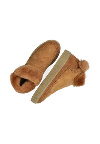 Botas de tobillo de ante color crema con un collar de pelaje sintético, acentos texturizados en marrón y una suela acolchada y decorada. Presentan costuras decorativas.