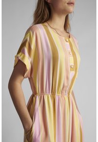 Robe légère à rayures avec des couleurs pastel jaune, rose et blanc, manches courtes, détail bouton et taille élastique avec poches.