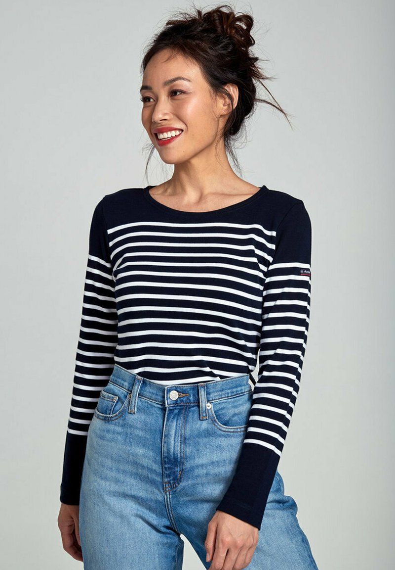 Marineblauw en witte gestreepte longsleeve top met een ronde halslijn, gecombineerd met lichtblauwe high-waisted jeans met een klassiek vijf-pocket ontwerp.