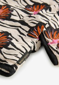Blomstret tørklæde med en cremet baggrund, sorte zebra-striber og livlige orange og pink blomster. Inkluderer en sort label med teksten "ROCKET & GEORGE."
