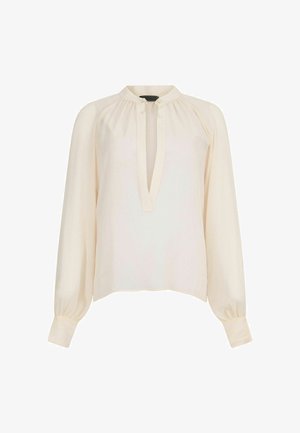 Krēmveida blūze ar garām, pūkainām piedurknēm, kurai ir atslēgas caurums un pogu detaļa. Gluda auduma virsma ar mīkstu, vieglu tekstūru.