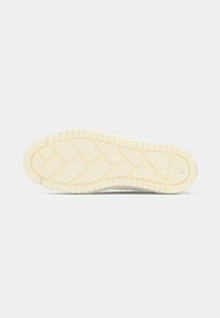 Semelle de basket en caoutchouc de couleur ivoire, présentant un motif chevron texturé et des indications de taille, conçue pour l'adhérence et la durabilité.