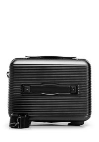 Black hard-shell textured suitcase with side handle and detachable shoulder strap placed beside it on white background.