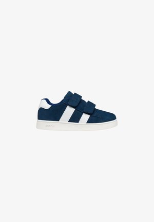 Zapatillas deportivas de ante azul marino con tiras de velcro blancas y detalles en blanco. Presentan una superficie texturizada y perforaciones a lo largo del lateral para mayor transpirabilidad.