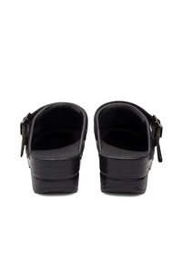 Sabots noirs avec un dos fermé, finition en cuir lisse, boucle réglable sur le côté et un petit talon épais.