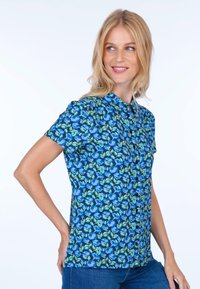 Short-sleeve shirt in blue with a floral pattern featuring green leaves. Fabric appears lightweight with a collar and button front closure.
