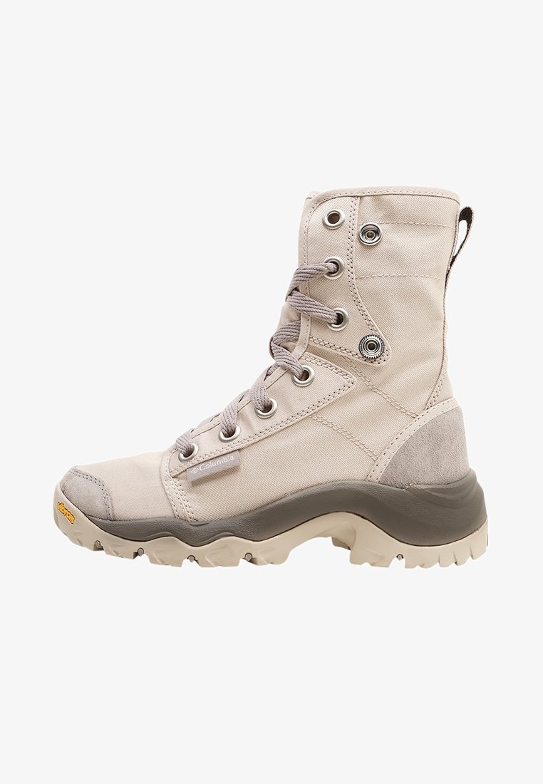 béžové kotníkové boty vyrobené z látky a semiše, s kovovými očky, kulatými tkaničkami, gumovou podrážkou a texturovanou spodní částí pro lepší přilnavost.