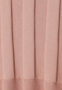 Úpletový svetr v jemné růžové barvě, s vertikálním žebrovaným vzorem a pevným spodním lemem. Materiál má hladký, lehký vzhled.