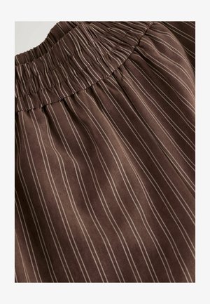 Bruine stof met verticale witte strepen, voorzien van een gerimpelde tailleband en zachte textuur. Het ontwerp benadrukt een subtiel, verfijnd patroon.