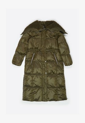 Olīvzaļš izolēts garais mētelis ar teksturētu kažokādas apkakli, ar rāvējslēdzēja sānu kabatām un elastīgu auklu jostasvietā. Puff izšūts dizains.