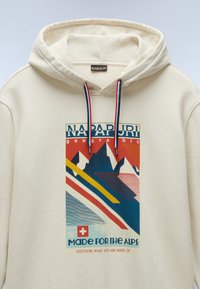 Kremowy hoodie z graficznym nadrukiem gór w kolorze niebieskim, czerwonym i żółtym. Posiada regulowany kaptur z kontrastowymi paskami.
