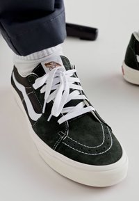 Zöld nubuk sneakers fehér fűzőkkel, fehér oldalcsíkkal, steppelt részletekkel és kerek orral, krém színű talpon.