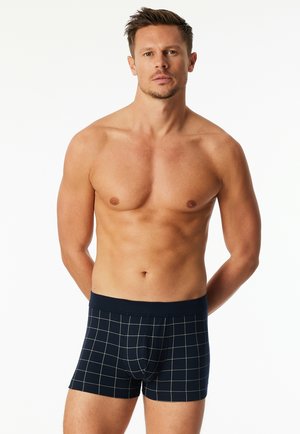 Boxer shorts in navy with a grid pattern in beige. Soft fabric with an elastic waistband. Fitted shape and mid-thigh length.